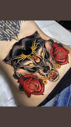 a woman's stomach with a cat and roses tattoo on her side ribcage