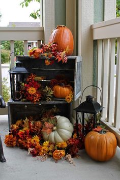 pumpkins and gourds are sitting on the porch