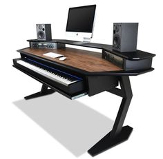 a computer desk with a keyboard, monitor and speakers sitting on it's sides