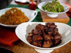 three bowls filled with food sitting on top of a wooden table next to other dishes