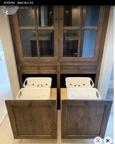 two wooden cabinets with white tubs in them