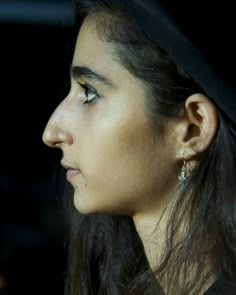 a close up of a person wearing a hat and looking off into the distance with her eyes closed