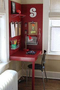 a red desk in the corner of a room