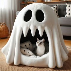 a cat is sitting in a ghost shaped bed