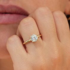 a woman's hand with a ring on her finger and a diamond in the middle