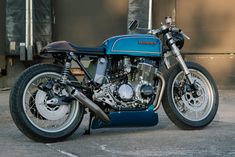 a blue and black motorcycle parked in front of a building with no one on it