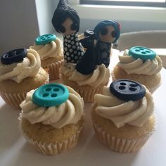 some cupcakes with buttons on them sitting on a table