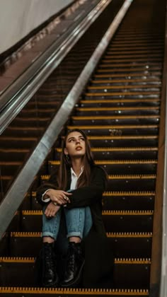 a woman sitting on an escalator looking up