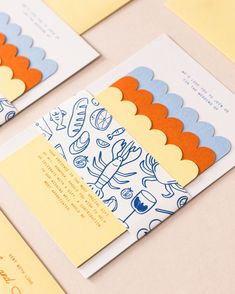 three cards with different designs on them sitting next to each other, one is yellow and the other is blue