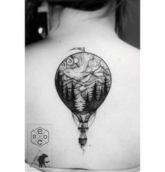 the back of a woman's shoulder with a hot air balloon tattoo on it