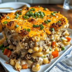 a white plate topped with macaroni and cheese casserole on top of a wooden table