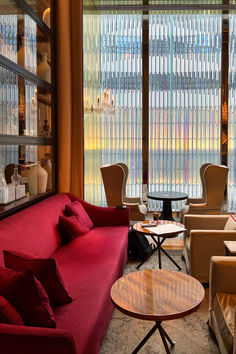 Modern luxury interior design style with luxe decor and a red velvet sofa against a glass partition at the Baccarat Hotel in NYC. Red Velvet Sofa