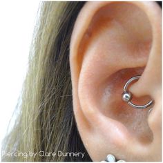 a close up of a person's ear with a nose ring