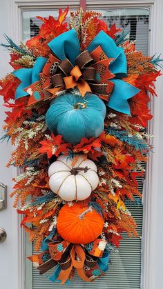 an orange, blue and white pumpkin wreath on a front door