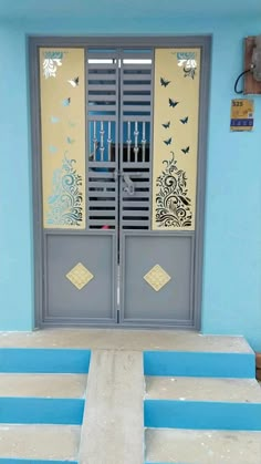 a blue and yellow building with two doors that have butterflies painted on the side of it