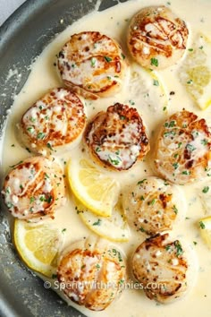 a pan filled with lemon and scallops covered in white sauce on top of a table