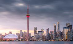 the city skyline is lit up in red, white and blue as the sun sets