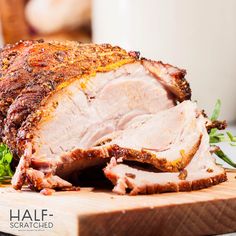 a large piece of meat sitting on top of a white plate next to some parsley