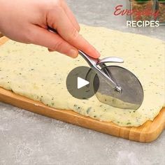 a person cutting cheese on top of a wooden board