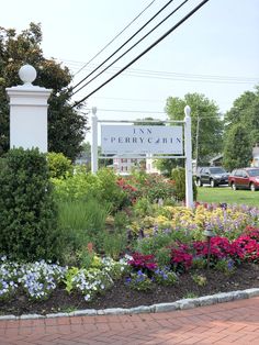 there is a sign in the middle of this flower garden