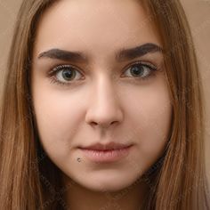 a woman with long brown hair and blue eyes is looking at the camera while she has her nose pierced