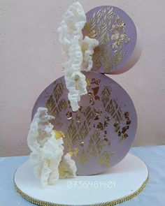 a cake with white frosting and gold leaves on it