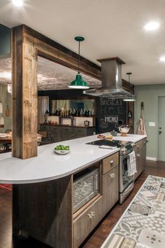 a kitchen with an island, stove top oven and counter space in the middle of it