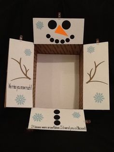 a snowman made out of cardboard sitting on top of a black table next to an empty box