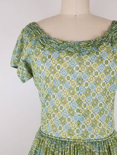 "Lovely green fit and flare dress from the late 40s I think (from the zipper). It has cute gathering around the neck line. Skirt is fully gathered at waist. Dress goes over the head and closes with a 11 inch 'Talon' brand green metal zipper on the side. The bodice is fully lined, but the skirt is not and the fabric is semi sheer so it may require a petticoat underneath (last photo I tried to show my hand thru the fabric. Photographed with white crinoline underneath). Nice construction of the arm Green Ruffled Vintage Dress, Green Vintage Dress With Ruffles, Green Retro Vintage Dress, Vintage Fitted Green Dress, Green Fitted Vintage Dress, 1950s Style Green Vintage Dress For Spring, Green Retro Vintage Dress With Short Sleeves, Vintage Green Dress For Garden Party, Green Retro Cotton Vintage Dress