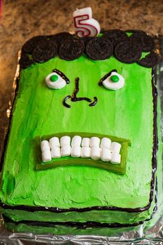 a green cake with white marshmallows in the shape of a monster's face