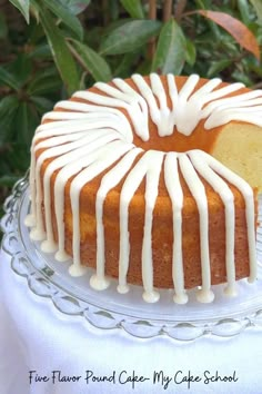 a bundt cake with white icing sitting on top of a glass platter