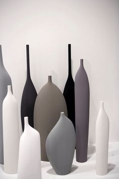 a group of vases sitting on top of a white table