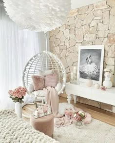 a living room with a hammock hanging from the ceiling and flowers on the floor