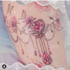 a woman's thigh with pink flowers and hearts on it, surrounded by lace