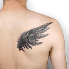 the back of a man's chest with an angel wing tattoo on it