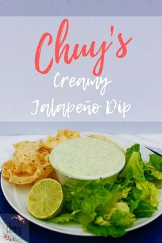 a plate with chips, lettuce and a lime on it that says chuy's creamy jalapeno dip