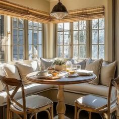 the breakfast table is set in front of two large windows