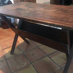 a wooden table sitting on top of a tiled floor