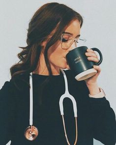 a woman with glasses and a stethoscope drinking out of a coffee cup