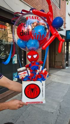 a spiderman balloon is being held up by someone