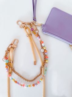 a purple purse and some bracelets on a table