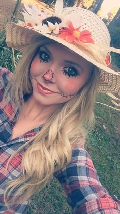 a woman wearing a hat with flowers painted on it's face is taking a selfie