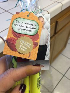 a person holding some pens and a card