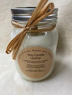 a jar filled with soy candle on top of a white blanket