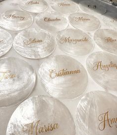 many personalized glass plates are arranged on a table top with gold lettering and names