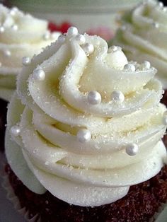 some cupcakes with white frosting and sprinkles