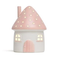 a pink and white ceramic house with lights on