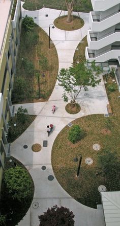 an aerial view of a courtyard with trees and people walking on the sidewalk in front of buildings