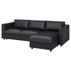 a black leather sectional sofa with chaise lounger in the back and footrests