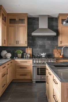 a kitchen with wooden cabinets and stainless steel appliances, including an oven hood over the range